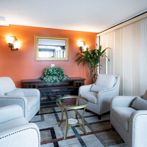 A bright, cozy living room with pastel couches, a dark coffee table, decorative shelves, and warm lighting&mdash;perfect for relaxing and entertaining.